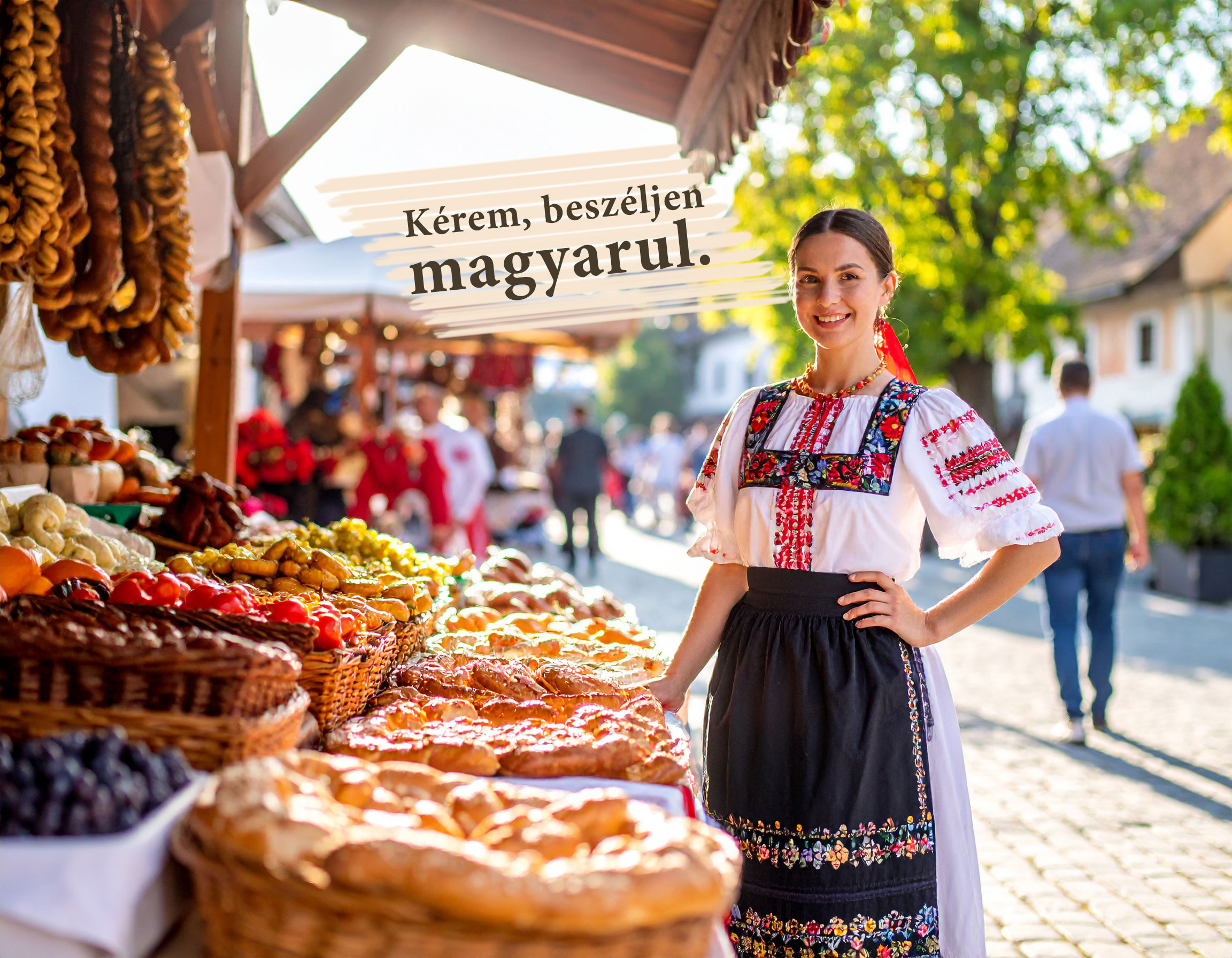 Ungarische Marktfrau in farbenfroher Tracht mit bestickter Bluse, umgeben von ungarischen Spezialitäten auf einem traditionellen Markt – Aufschrift: Kérem, beszéljen magyarul.